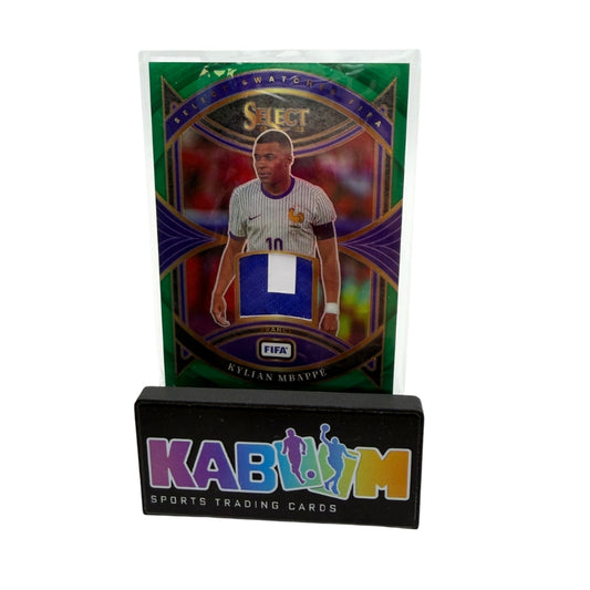 A collectible sports trading card featuring Kylian Mappie, displayed on a black stand branded KABooM Sports Trading Cards. The card has a green and purple metallic design with a blue and white fabric swatch patch.